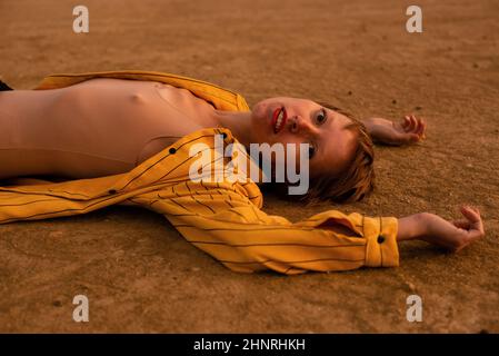 femme avec un tissu orange se trouve dans le désert Banque D'Images