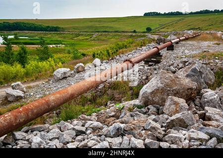 La grande lagune de décantation à Cavendish Mill est située près de Stoney Middleton, avec un pipeline en acier rouillé le long du bord. Banque D'Images