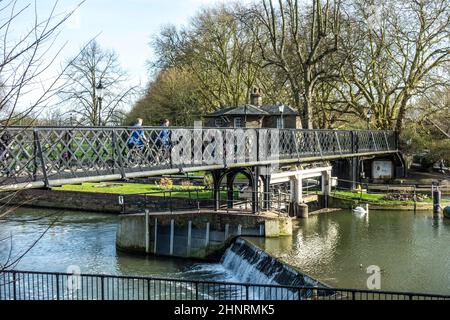 personnes traversant la rivière cam à un vieux pont piétonnier en fer Banque D'Images