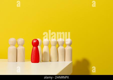 figurines en bois d'hommes et une rouge sur fond bleu.Concept de responsable et de recrutement.Personnalité toxique dans l'équipe Banque D'Images