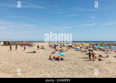 les gens apprécient la plage de sable lors d'une chaude journée d'été Banque D'Images