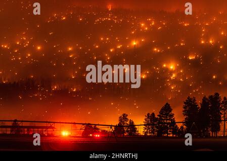 Un feu de forêt de Californie brûle sur une crête de montagne près des champs agricoles Banque D'Images