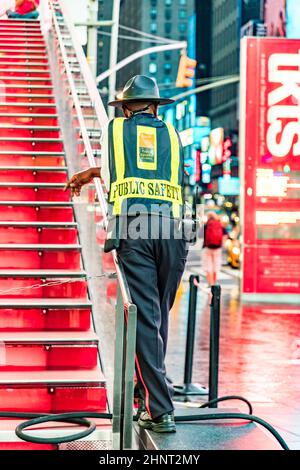 L'homme de sécurité en début de matinée observe les gens à Times Square en début de matinée Banque D'Images