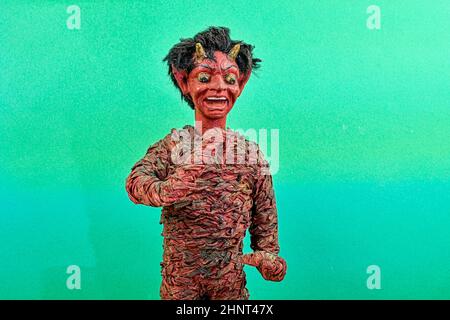 Figure de Krampus ou diable. Tradition d'Europe centrale. Le Krampus ou diable est dans la tradition d'une figure de la droite en compagnie de Saint-Nicolas. Figurine diable sur fond vert Banque D'Images