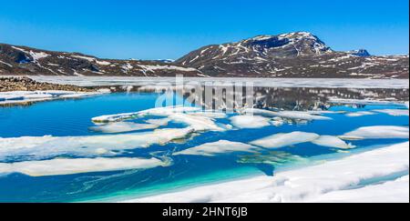 Lac turquoise gelé Vavatn panorama en été paysage et montagnes avec neige à Hemsedal Norvège. Banque D'Images