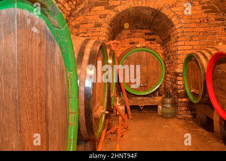 Fûts de vin empilés dans une cave.Fûts de vin dans une cave à vin, ancienne cave à vin avec plafonds voûtés en briques.Vinification traditionnelle Banque D'Images