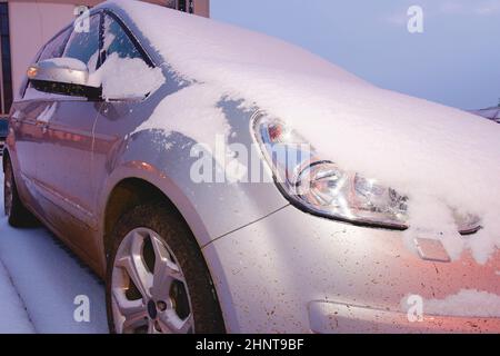 Gros plan d'une voiture recouverte de neige. Voiture argentée en hiver. Banque D'Images