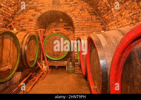 Fûts de vin dans une cave à vin, ancienne cave à vin avec plafonds voûtés en briques.Vinification traditionnelle Banque D'Images