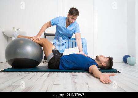 Le physiothérapeute aide les jeunes patients à faire des exercices pilates. Banque D'Images