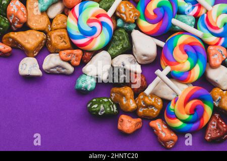 Sucettes et bonbons. Bonbons sous forme de pierres colorées. Fond coloré avec bonbons colorés. Décoration festive Banque D'Images