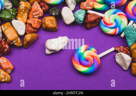 Sucettes et bonbons. Bonbons sous forme de pierres colorées. Fond coloré avec bonbons colorés. Décoration festive Banque D'Images