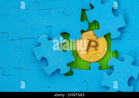 Puzzle bleu avec bitcoin doré en dessous Banque D'Images