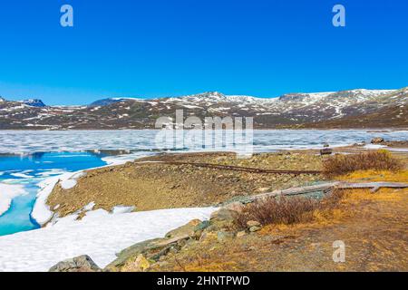 Lac turquoise gelé Vavatn panorama en été paysage et montagnes avec neige à Hemsedal Norvège. Banque D'Images