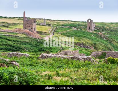 De vieux vestiges célèbres de mines d'étain s'éparpillés autour de la zone rurale de bruyère luxuriante et d'herbe entourant Botallack, sur les falaises et le terrain rocheux de NOR Banque D'Images