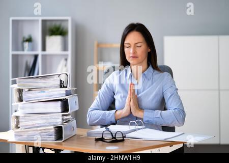 Femme faisant de la comptabilité gestion du stress exercice de yoga sur le lieu de travail Banque D'Images
