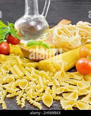 Pâtes à coque en cuillère, truquage de tuyaux, spaghetti, tagliatelles, fusilli, penne, farfalle, trenette, tomates, ail, huile végétale en carafe et par Banque D'Images