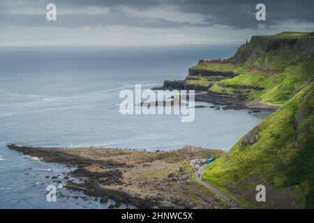 Une foule de touristes visitant la chaussée de Giants, vue depuis le sommet de la falaise, la voie de l'Atlantique sauvage et le patrimoine mondial de l'UNESCO, situé en Irlande du Nord Banque D'Images