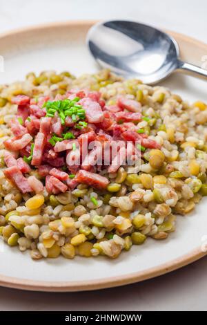 porridge de légumineuses avec bacon frit et ciboulette Banque D'Images
