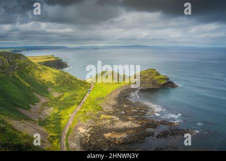 Touristes et bus sur le sentier de Giants Causeway, vu du haut de la falaise, Wild Atlantic Way et patrimoine mondial de l'UNESCO, situé en Irlande du Nord Banque D'Images