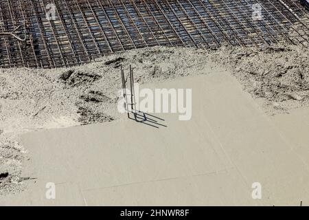 détail de la tige en fer sur une fondation en béton avec du ciment humide Banque D'Images