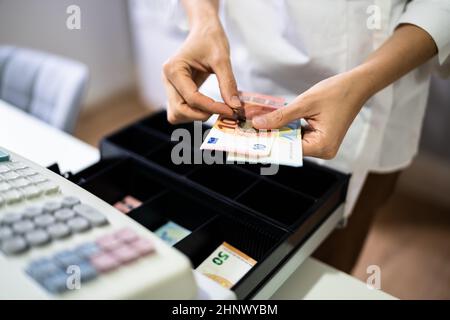 Main du caissier travailler avec la caisse enregistreuse changer la facture d'argent Banque D'Images