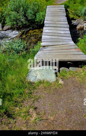 Petit pont en bois et sentier au-dessus de la rivière du lac Vavatn à Hemsedal, Norvège. Banque D'Images