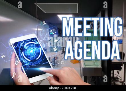 Signature manuscrite ordre du jour de la réunion, Internet concept points que les participants espèrent accomplir à une réunion Homme en tenue debout uniforme tablette Typi Banque D'Images