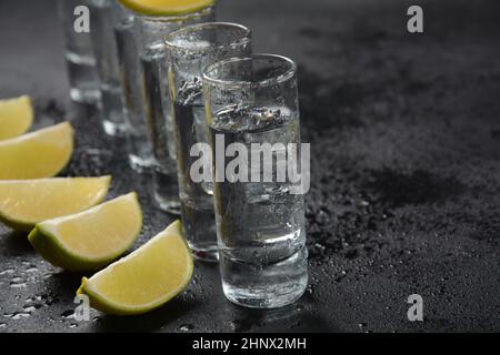 Apéritif entre amis au bar, verres d'alcool au citron vert pour la décoration.Tequila, vodka, whisky, rhum. Banque D'Images