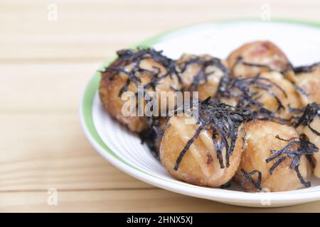 Takoyaki délicieux en-cas japonais le plus populaire avec de la mayonnaise sur une assiette blanche. Mise au point douce sélectionnée. Ou boulettes de pieuvre cuisine japonaise. Gros plan Banque D'Images