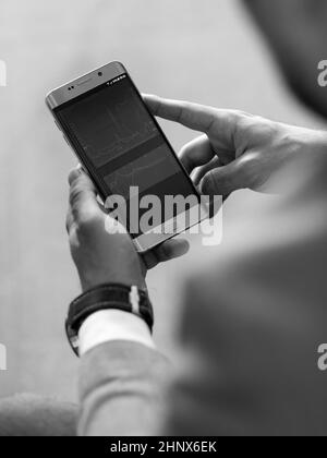 Gros plan sur un homme d'affaires utilisant un smartphone. Se concentrer sur les appareils mobiles. Image en noir et blanc. Banque D'Images