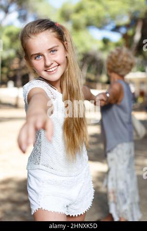 Une jeune fille tire la main et garde la grand-mère à portée de main dans le parc vert Banque D'Images