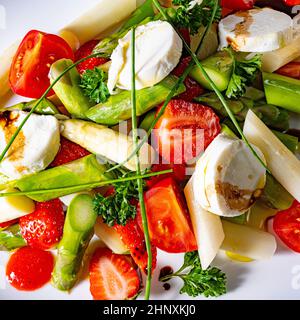 Salade d'asperges avec fraises, tomates et fromage de chèvre Banque D'Images