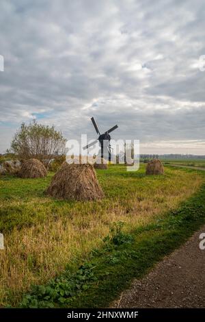 Ancien moulin à vent et piles de foin, Kinderdijk, pays-Bas Banque D'Images