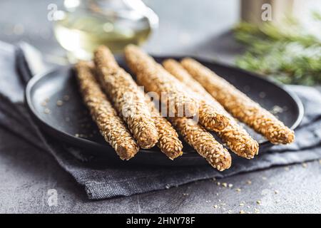 Gressins graissini.Bâtonnets de pain avec graines de sésame sur l'assiette. Banque D'Images