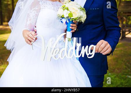 Dans les mains de la jeunes mariés mariage lettres en bois. Banque D'Images