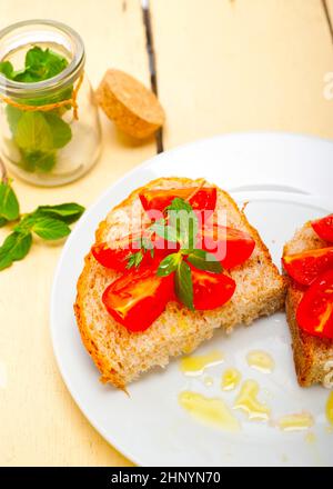 Bruschetta aux tomates italiennes avec le thym et les feuilles de menthe Banque D'Images