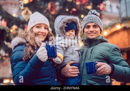 Famille avec enfant s'amuser au marché de Noël en appréciant la saison Banque D'Images