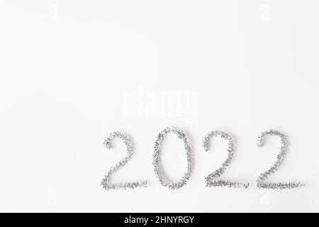 Bonne année 2022 écrite en papier d'aluminium et pluie du nouvel an sur un fond blanc isolé.Bonne année salutations Banque D'Images