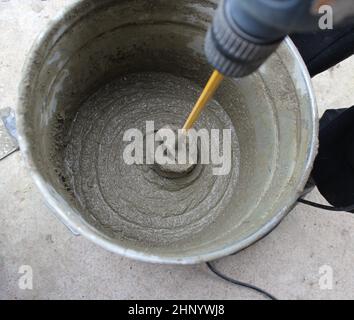 Mélange du béton avec perceuse électrique et mélangeur. Banque D'Images