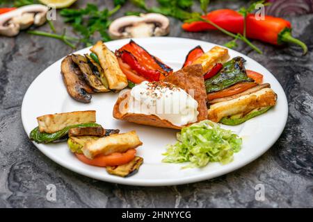 Légumes grillés au fromage halloumi sur une assiette en porcelaine blanche Banque D'Images