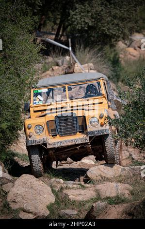 Un cliché vertical d'un ancien Land Rover Santana jaune qui roule sur une route rocheuse Banque D'Images