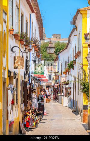 Promenade touristique dans la rue pavée de la ville médiévale d'Obidos. Portugal Banque D'Images