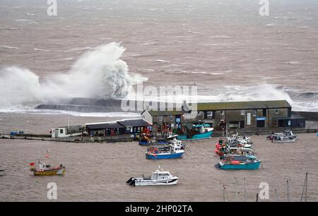 Vagues crash contre la Cobb dans Lyme Regis, Dorset ouest, comme la tempête Eunice frappe la côte sud, avec des attractions de fermeture, la perturbation de voyage et un incident majeur déclaré dans certaines régions, ce qui signifie que les gens sont avertis de rester à l'intérieur. Un avertissement rare de temps rouge - l'alerte la plus élevée, ce qui signifie qu'un impact élevé est très probable - a été émis par le bureau met en raison de la combinaison de marées hautes, de vents forts et de la montée de tempête. Date de la photo : vendredi 18 février 2022. Banque D'Images