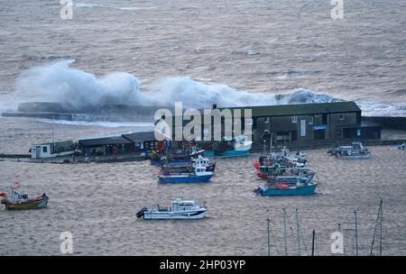 Vagues crash contre la Cobb dans Lyme Regis, Dorset ouest, comme la tempête Eunice frappe la côte sud, avec des attractions de fermeture, la perturbation de voyage et un incident majeur déclaré dans certaines régions, ce qui signifie que les gens sont avertis de rester à l'intérieur. Un avertissement rare de temps rouge - l'alerte la plus élevée, ce qui signifie qu'un impact élevé est très probable - a été émis par le bureau met en raison de la combinaison de marées hautes, de vents forts et de la montée de tempête. Date de la photo : vendredi 18 février 2022. Banque D'Images