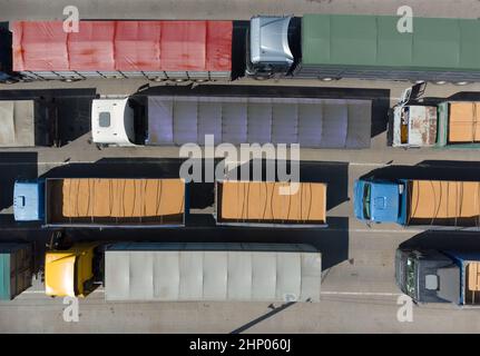 Transport de marchandises. De nombreux camions attendent en file d'attente pour le déchargement dans le port portuaire, vue de dessus d'un quadricoptère sur les camions chargés de grain. Concep Banque D'Images