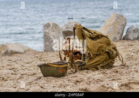 La deuxième guerre mondiale. Casque et sac à dos militaire d'un soldat américain sur la plage Banque D'Images