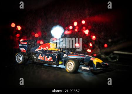 Image d'un Red Bull de Formule 1 en action avec la pluie et les rétroéclairages. Banque D'Images