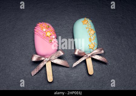 deux cake pops décorés glaces avec des noeuds sur fond noir. Vue de dessus. Banque D'Images