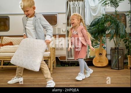 Frère et sœur s'amusant à la remorque, camping d'été. La famille avec des enfants voyage dans la voiture de camp, la nature et la forêt en arrière-plan. Camping adven Banque D'Images