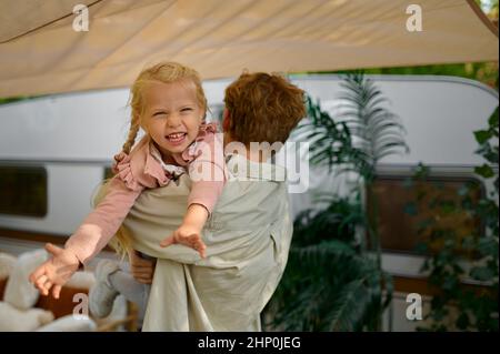 Père et gaughter s'amuser à la remorque, camping d'été.Les familles avec enfants voyagent en voiture de camp, dans la nature et dans la forêt en arrière-plan.Camping aventur Banque D'Images